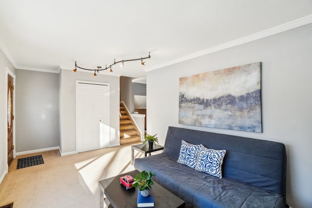 carpeted living room featuring baseboards, track lighting, stairway, and crown molding