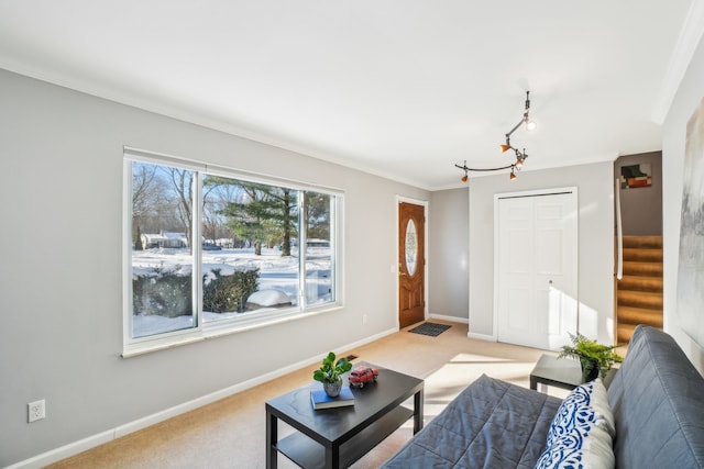 living room with light carpet, rail lighting, stairs, and baseboards