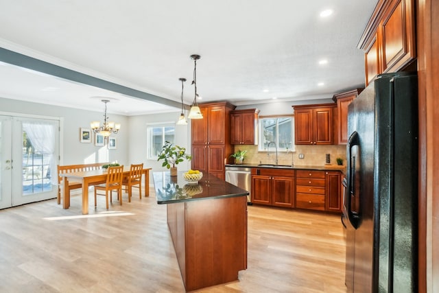 kitchen with a center island, dishwasher, black refrigerator with ice dispenser, dark countertops, and decorative light fixtures