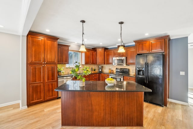 kitchen featuring appliances with stainless steel finishes, a kitchen island, decorative light fixtures, and tasteful backsplash