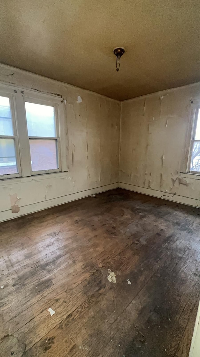 unfurnished room featuring dark hardwood / wood-style floors and a healthy amount of sunlight