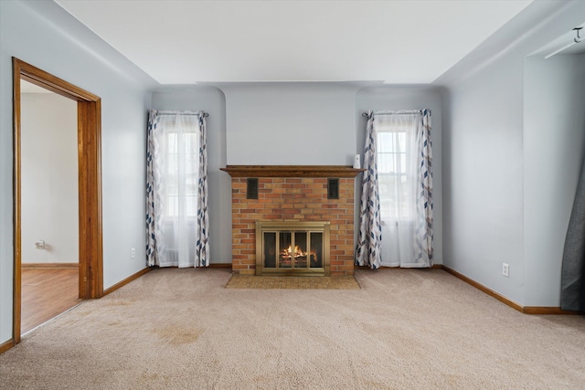 unfurnished living room with light colored carpet and a brick fireplace