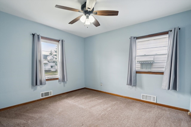 carpeted spare room with ceiling fan