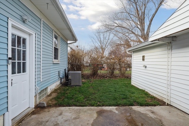 view of yard with central AC and a patio