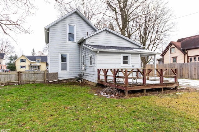 back of house featuring a lawn and a wooden deck