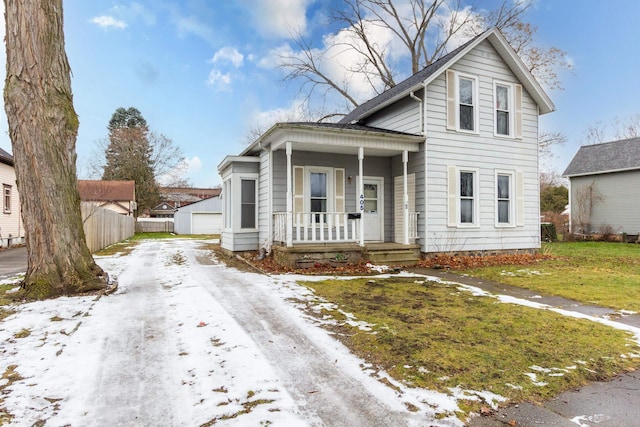 view of front of house with an outbuilding, a yard, a garage, and covered porch