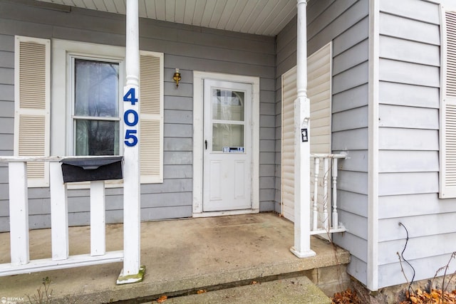 view of exterior entry featuring covered porch