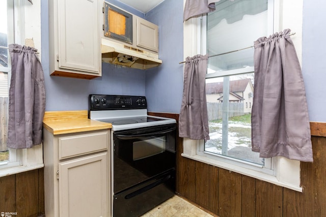 kitchen with black electric range oven and white cabinetry