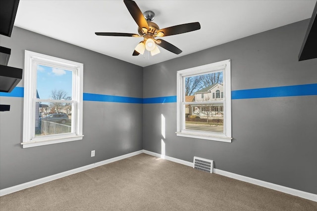 spare room featuring ceiling fan, a wealth of natural light, and carpet floors