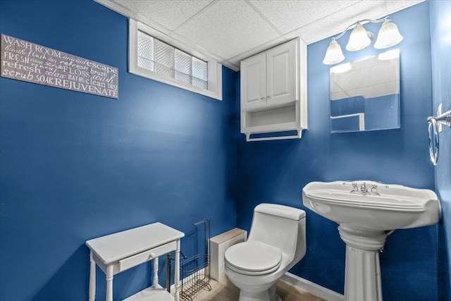 bathroom with toilet and a drop ceiling