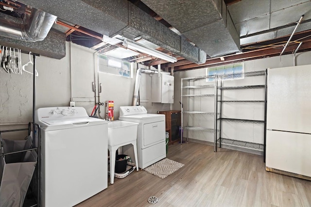 laundry room with sink, washer and clothes dryer, and light wood-type flooring