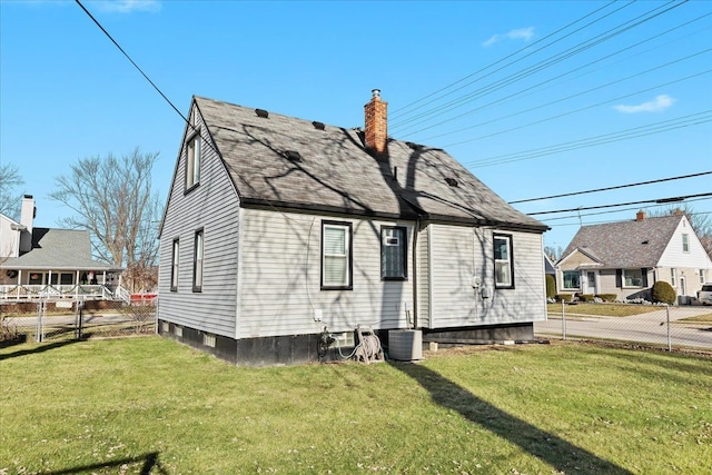 exterior space with central air condition unit and a yard