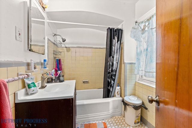 bathroom featuring plenty of natural light, shower / tub combo with curtain, vanity, and tile walls