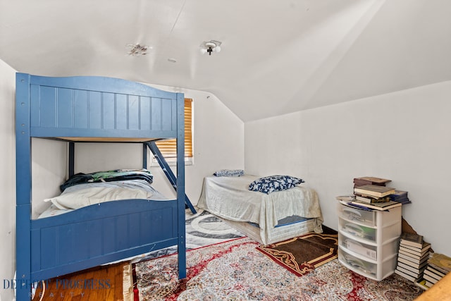 bedroom with wood-type flooring and vaulted ceiling