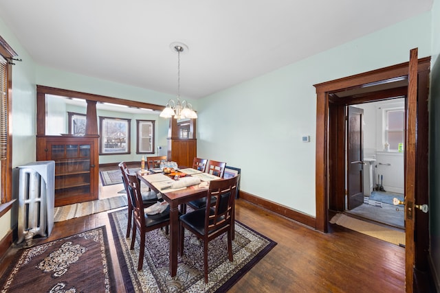 dining room with radiator heating unit, dark hardwood / wood-style flooring, and a notable chandelier