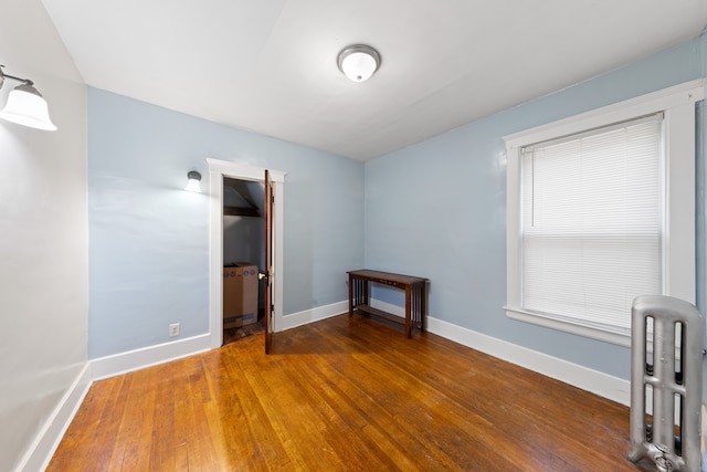 unfurnished room with dark hardwood / wood-style flooring