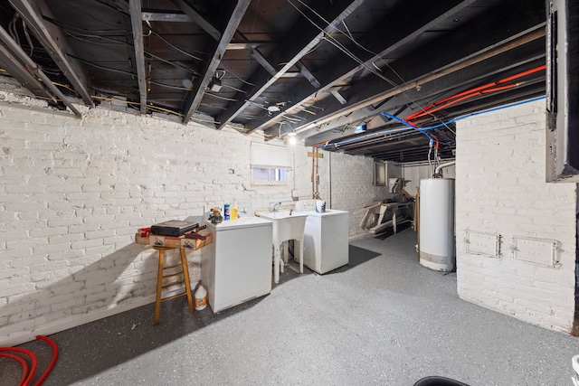 basement featuring sink, washing machine and clothes dryer, refrigerator, and water heater