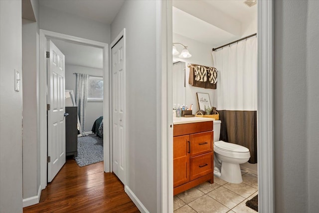 bathroom with tile patterned flooring, vanity, and toilet