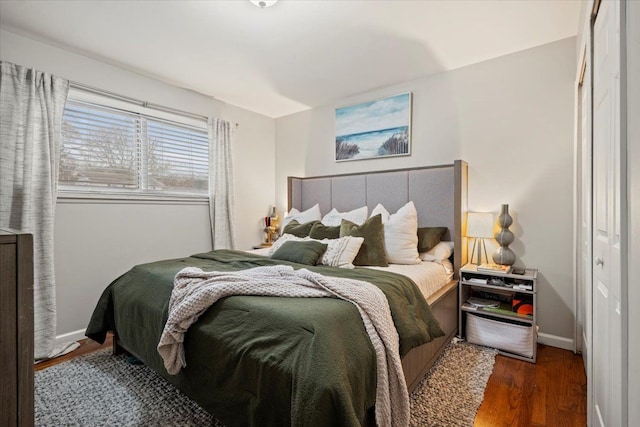 bedroom with dark hardwood / wood-style floors and a closet