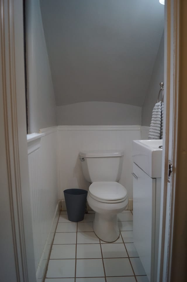 bathroom featuring tile patterned floors, vanity, vaulted ceiling, and toilet