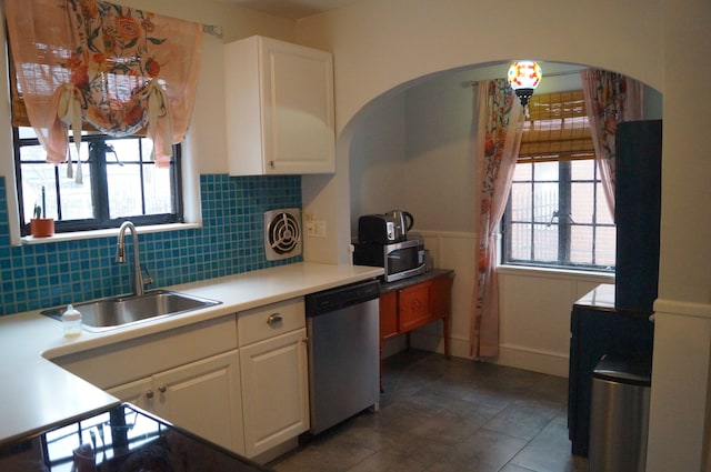 kitchen with white cabinetry, sink, decorative backsplash, dark tile patterned flooring, and appliances with stainless steel finishes