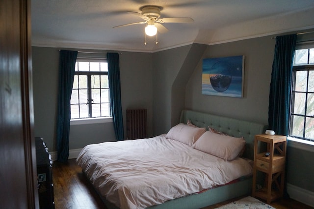 bedroom featuring ceiling fan, crown molding, dark wood-type flooring, and radiator