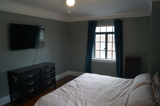 bedroom with dark hardwood / wood-style floors, crown molding, and radiator