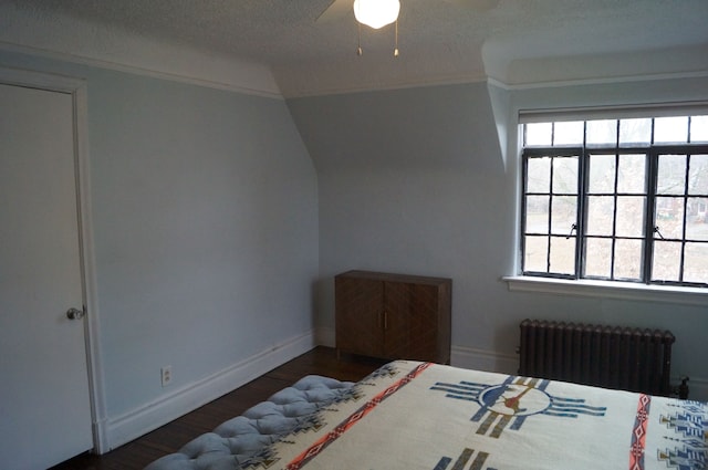 bedroom with ceiling fan, dark hardwood / wood-style floors, and radiator