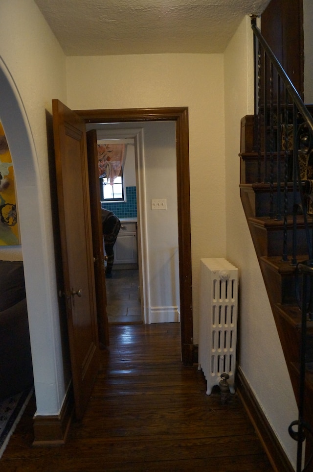 corridor featuring dark hardwood / wood-style flooring and radiator