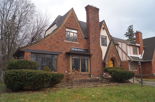 english style home with a front lawn