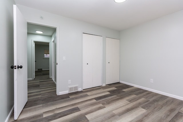 unfurnished bedroom with dark hardwood / wood-style floors