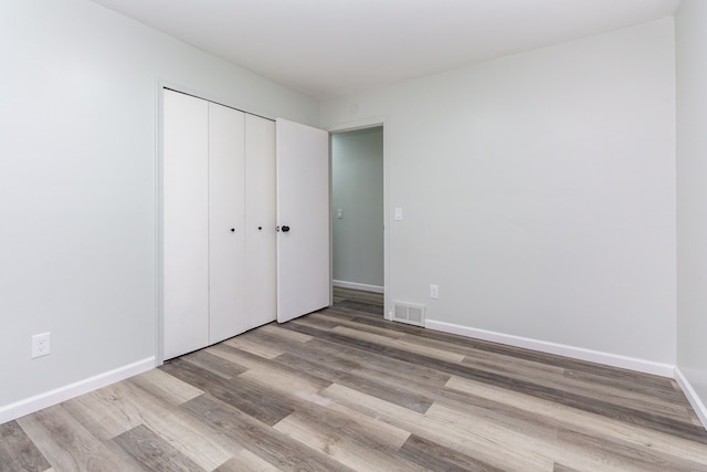 unfurnished bedroom with a closet and light hardwood / wood-style flooring