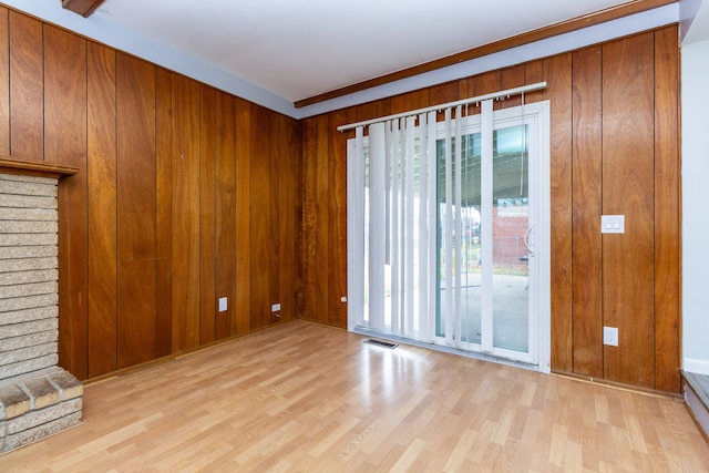 interior space featuring wood walls, light hardwood / wood-style flooring, and crown molding