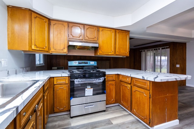 kitchen with gas stove, kitchen peninsula, and light wood-type flooring