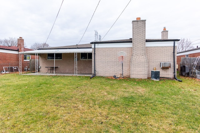 rear view of house with a patio area and a lawn