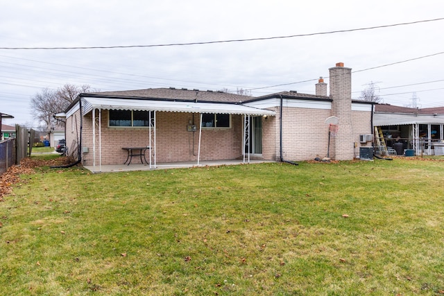 rear view of property with a yard, a patio, and central air condition unit