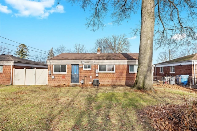 back of house with central air condition unit and a lawn