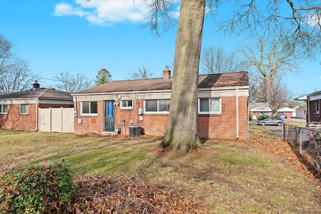 back of property with a lawn and central AC