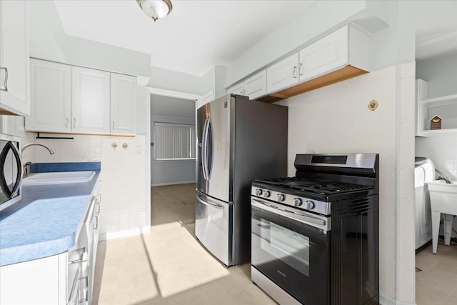 kitchen with sink, white cabinets, and appliances with stainless steel finishes