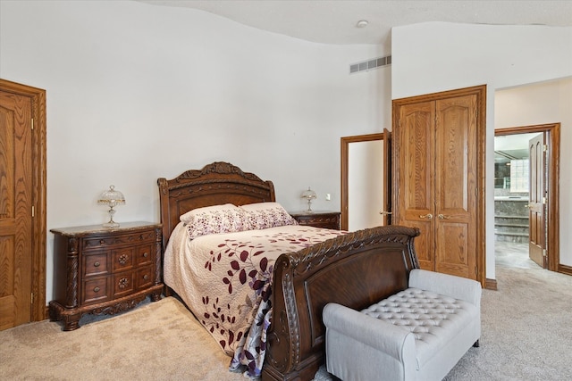 bedroom with light colored carpet and lofted ceiling