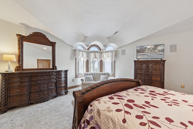 bedroom featuring carpet floors, vaulted ceiling, and a textured ceiling