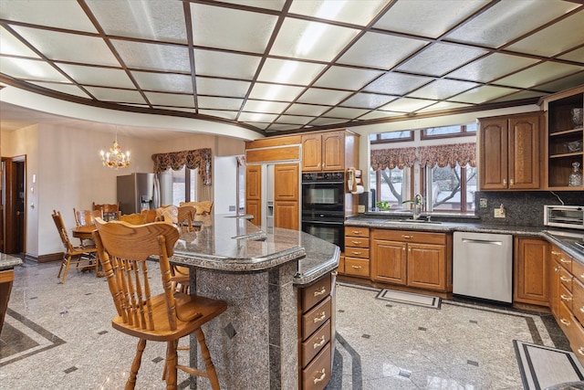 kitchen featuring a breakfast bar, sink, a center island, stainless steel appliances, and backsplash