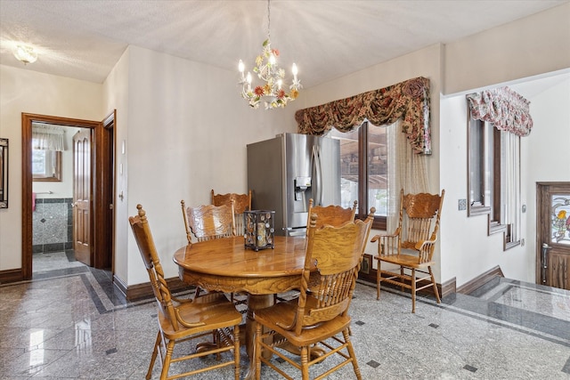 dining area with an inviting chandelier and a textured ceiling