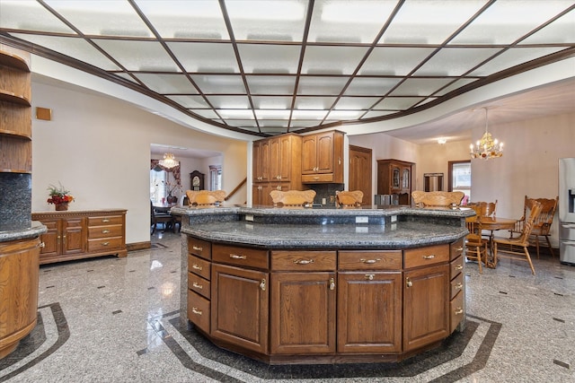 kitchen with stainless steel refrigerator with ice dispenser, a kitchen island, pendant lighting, and backsplash