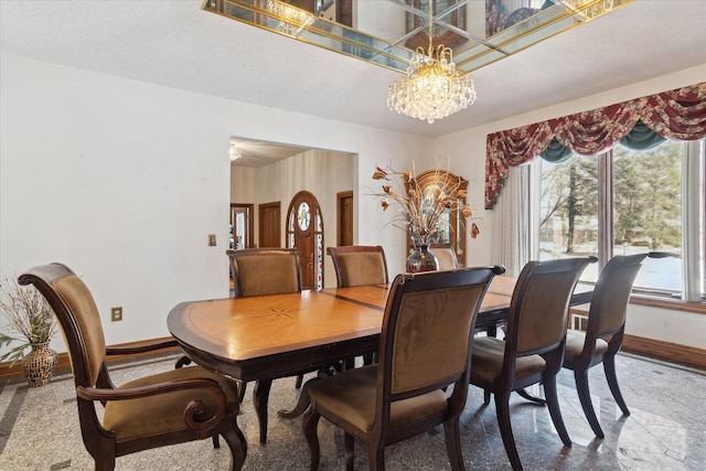 dining space with a notable chandelier and a textured ceiling