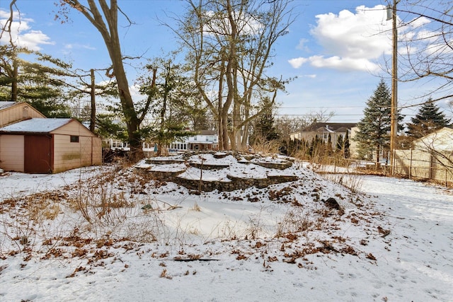 yard covered in snow with a garage and an outbuilding