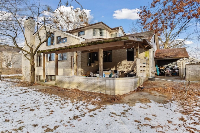 view of snow covered back of property