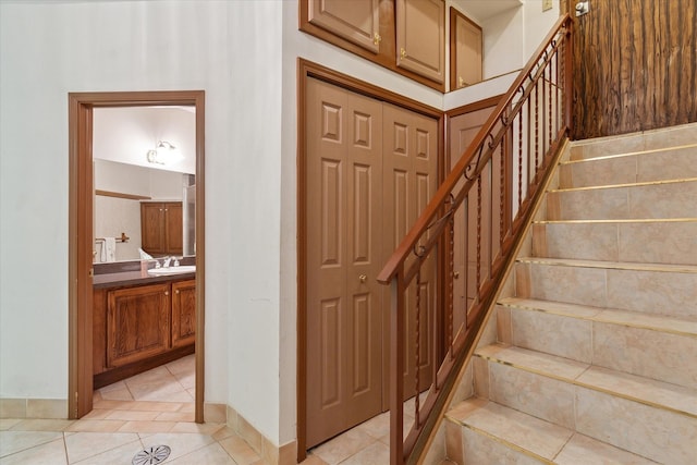 stairway featuring sink and tile patterned floors