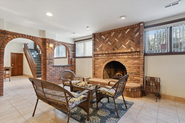 interior space with a brick fireplace and light tile patterned flooring