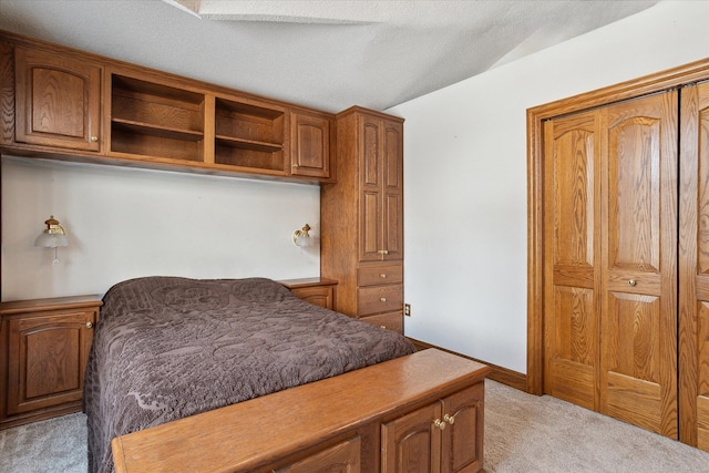 carpeted bedroom featuring lofted ceiling, a textured ceiling, and a closet